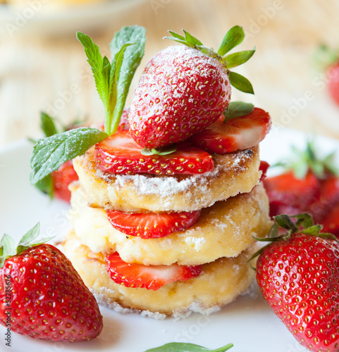  stack of homemade curd pancake with strawberry slices