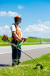 Road landscapers cutting grass using string lawn trimmers