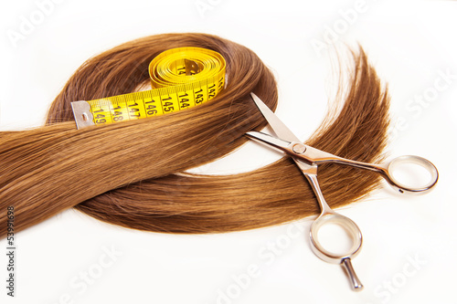 Fototapeta hairdresser scissors on hair with measuring tape