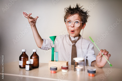 Fototapeta Crazy scientist. Young boy performing experiments