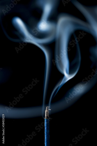 Fototapeta smoke from the incense stick on black background