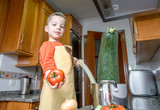 cute child chef cooking big zucchini in a pot