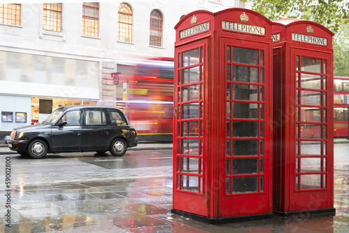  Red Phone cabines in London and vintage taxi.Rainy day.