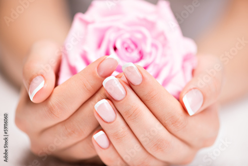 Zdjęcia Beautiful woman's nails with french manicure and rose