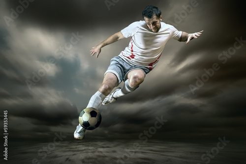 Fototapeta Football player with ball on field of stadium