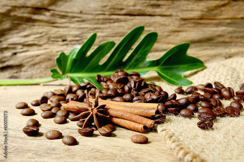 Roasted coffee beans  on sackcloth with grunge wooden  backgroun