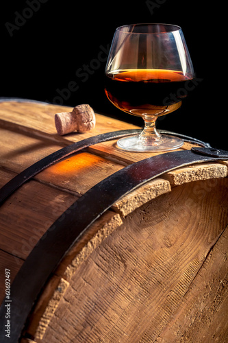  Glass of cognac on the vintage wooden barrel