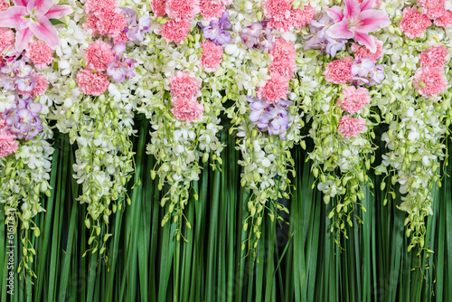 Fototapeta Green backdrop flowers arrangement for wedding ceremony