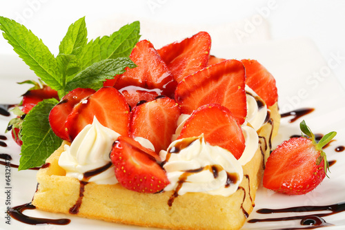 Fototapeta Crisp waffle with strawberries and cream