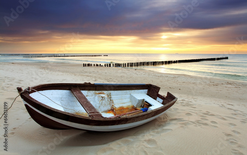 Obraz na płótnie Boat on beautiful beach in sunrise