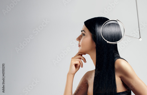 Fototapeta Portrait of a woman with a lens showing ideal hair