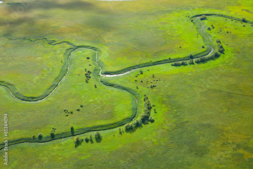 Fototapeta small river on the green meadow