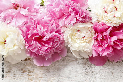 Fototapeta Stunning pink peonies, yellow carnations and roses on rustic