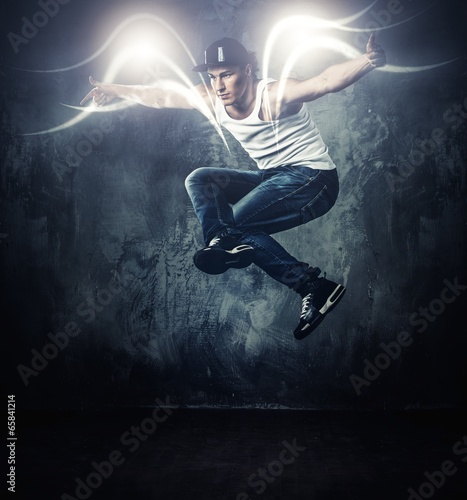 Fototapeta Stylish break-dancer dancing with magic beams around him