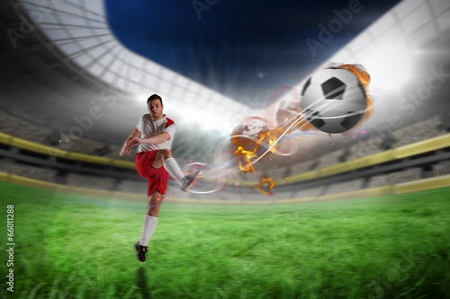 Fototapeta Composite image of football player in white kicking