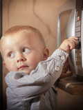 Boy child kid playing with timer of microwave oven