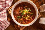 overhead photo of a bowl of chili with cheese and green onions poster
