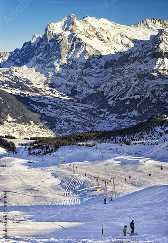  People on ski and snowboards near cable railway on winter sport