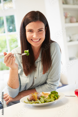 Portrait Of Woman Eating Healthy Meal In Kitchen