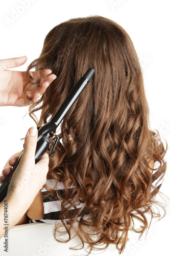Zdjęcia Stylist using curling iron for hair curls, close-up, isolated