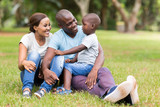 young african family sitting outdoors poster