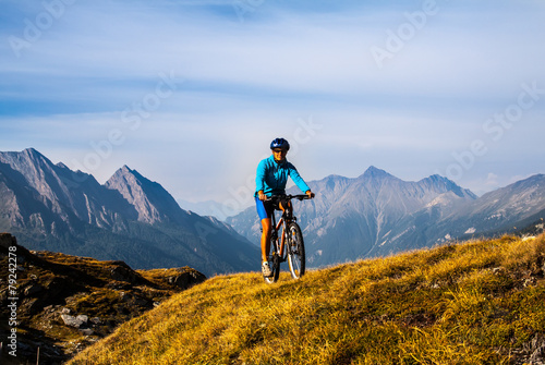 Fototapeta Cyclist woman in hight mountais