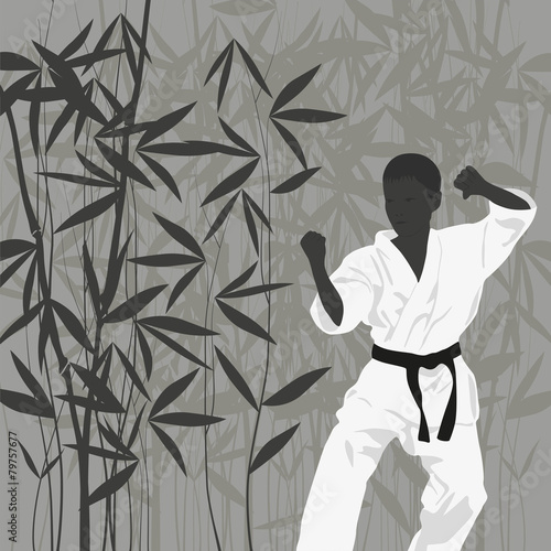 The boy is engaged in karate on a light background. © zhelunovych