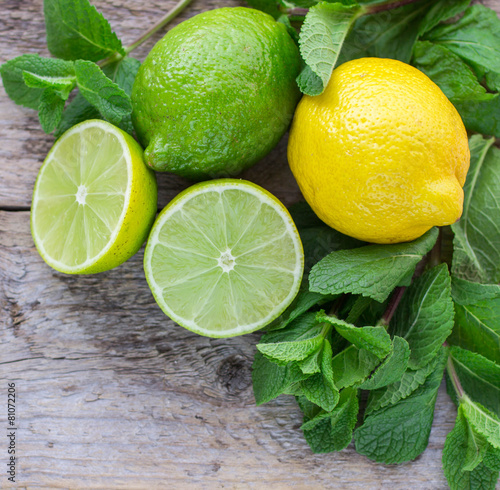 Juicy ripe citrus on an old wooden table - lime, lemon and mint