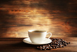 Cup of coffee with grains on wooden background poster