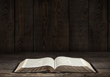 Bible. Image of an old Holy Bible on wooden background in a dark poster