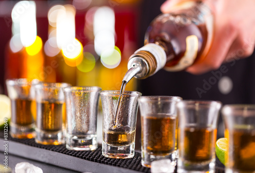 Zdjęcia Barman pouring hard spirit into glasses