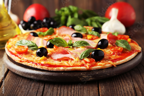 Poster Delicious fresh pizza on brown wooden background