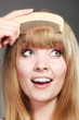 Closeup woman combing her fringe with comb