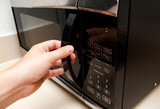 Hand opening microwave oven close up