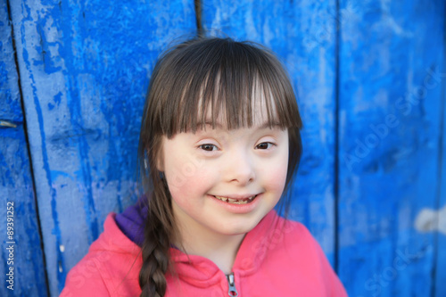 Young girl smiling on background of the blue wall