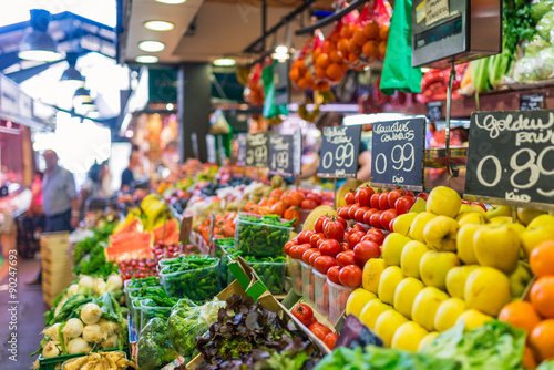 Poster Price tags on market stall, fruits and vegetables for sale at La Boqueria