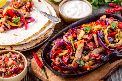 Zdjęcia Pork fajitas with onions and colored pepper, served with tortill