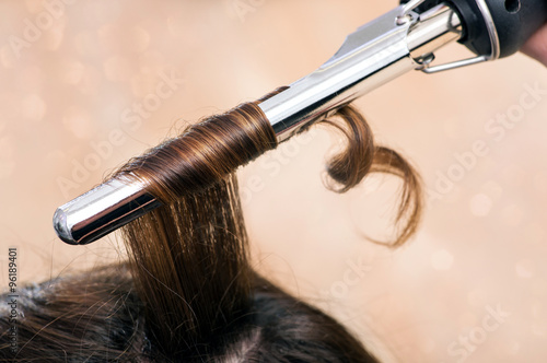 Zdjęcia Hairstylist using a curling iron or tongs