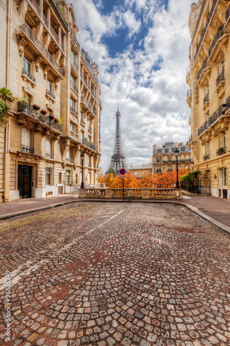  Eiffel Tower seen from the street in Paris, France. Cobblestone pavement