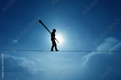 Concept of risk taking and challenge highline walker in blue sky