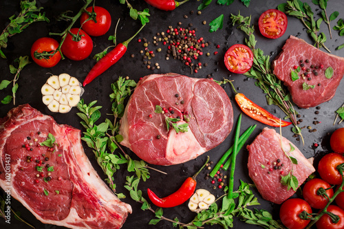Zdjęcia Raw meat steaks on a dark background ready to roasting