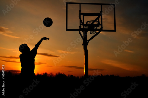 Obraz na płótnie Silhouette of Teen Boy shooting a Basketball