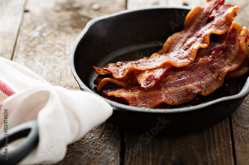 Sizzling hot bacon in a cast iron skillet