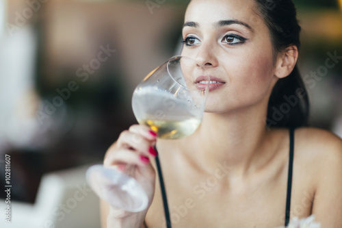 Poster Attractive woman tasting white wine