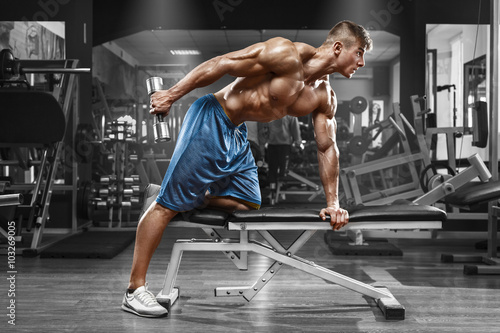 miesniowy-mezczyzna-pracujacy-w-gym-robi-cwiczeniom-z-dumbbells-przy-triceps-out-silny-meski-nagi-polpostaci-abs