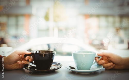 Friends holding cup of coffee
