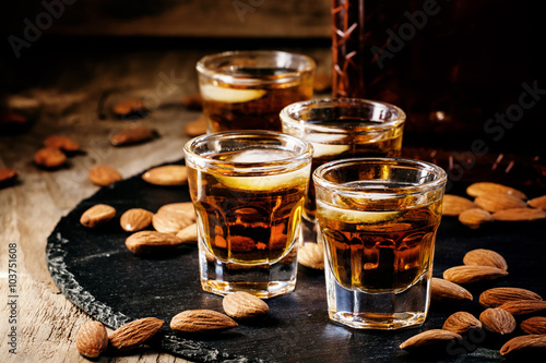 Brandy and almonds, small glasses on a dark background, selectiv