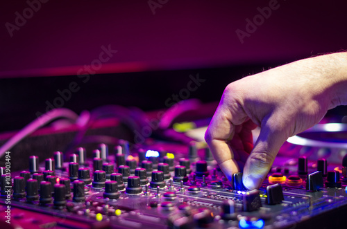 Poster Dj mixes the track in the nightclub at party - music and technology concept