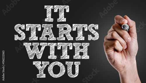 Hand writing the text: It Starts With You