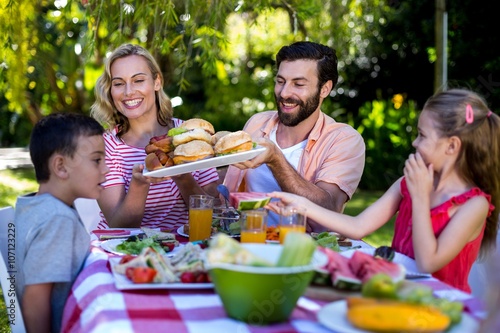 Happy family having meal in yard 